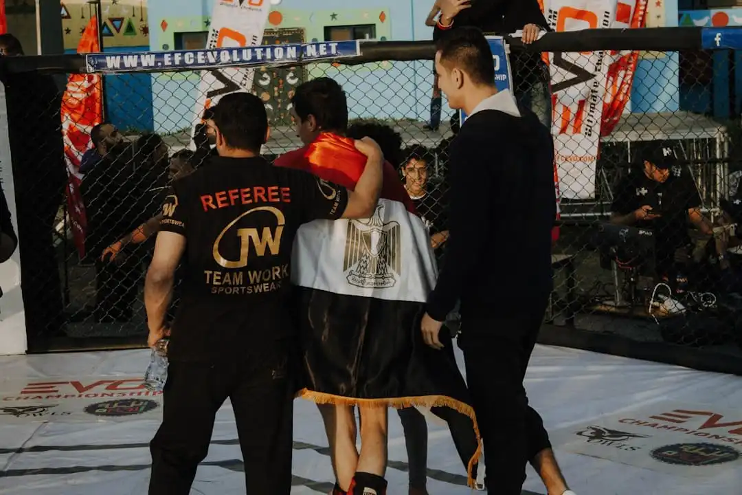 A group of men standing around a man sitting on a chair